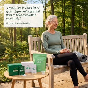 Woman in her 60s relaxing on a forest bench after yoga, Silvie Body, Body Pro and Mind beside her, with a customer review