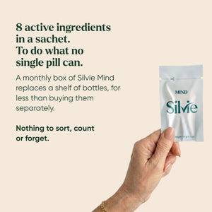 Hand holding a Silvie Mind sachet: 8 active ingredients in one daily sachet instead of a shelf of supplements