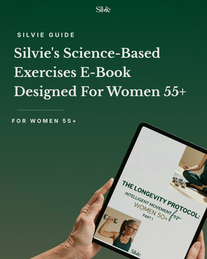 A hand holds a tablet displaying The Longevity Protocol E-book, an exercise guide for women over 50 featuring photos of a woman strength training.